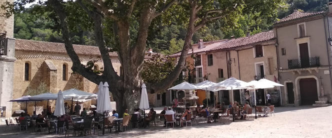 place du village de Saint Guilhem le Désert avec ses café et restaurants